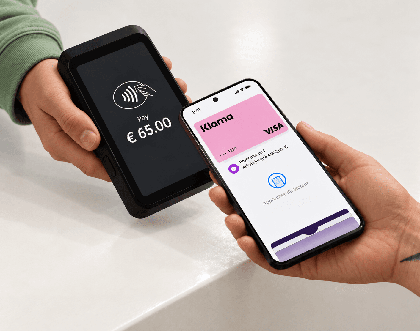 A client holds a phone showing a Klarna card near a payment terminal.