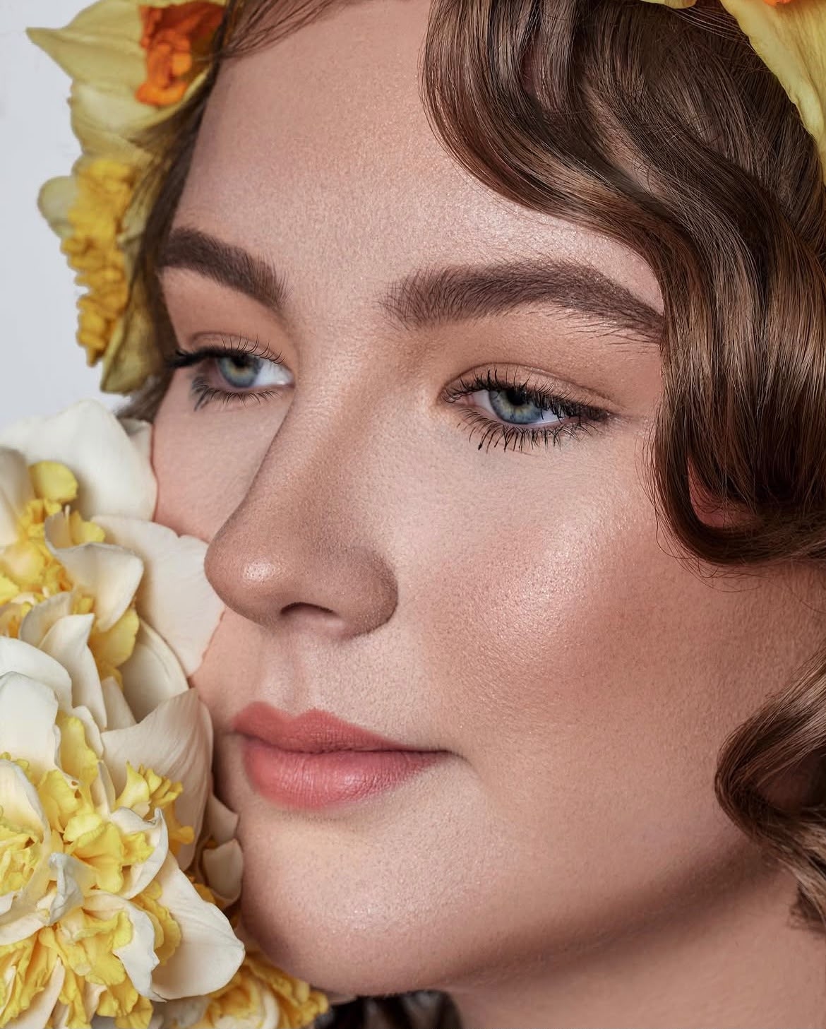 Editorial beauty portrait with flowers and waved hair